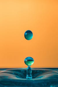 Mesmerizing close-up of turquoise water droplets against a striking orange background. Värianalyysit Järvenpäässa ja muualla Uudellamalla.