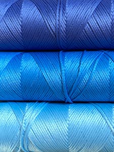 Vibrant blue yarn rolls showcasing layered textures for design inspiration.
